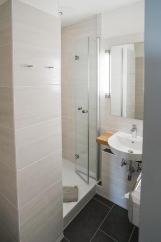 a white bathroom with a sink and a shower at acama Hotel & Hostel Kreuzberg in Berlin