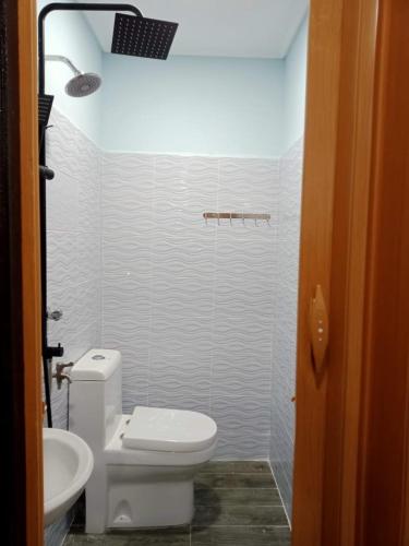 a white bathroom with a toilet and a sink at Teratak Damai STC in Kuala Terengganu