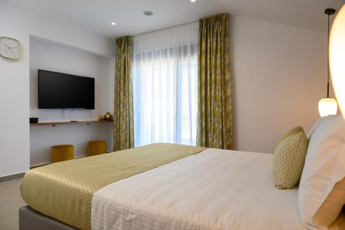 a hotel room with a bed and a television at Αntheon Apartment 3 in Agios Nikolaos