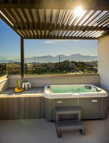 a jacuzzi tub in a room with a large window at Αntheon Apartment 3 in Agios Nikolaos