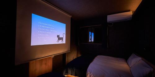 a projection screen in a room with a bed at Rakuten STAY HOUSE Kujukuri Ichinomiya in Ichigaya