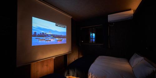a tv hanging on a wall in a bedroom at Rakuten STAY HOUSE Kujukuri Ichinomiya in Ichigaya