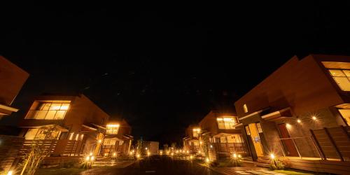 a city street with buildings at night with lights at Rakuten STAY HOUSE Kujukuri Ichinomiya in Ichigaya