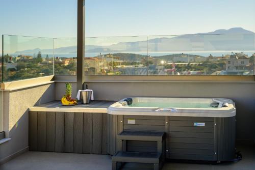 a hot tub in a room with a large window at Αntheon Apartment 3 in Agios Nikolaos