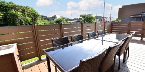 a table and chairs on a deck with a fence at Rakuten STAY HOUSE Kujukuri Ichinomiya in Ichigaya