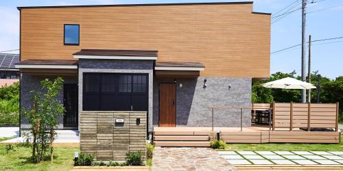 a house with an umbrella in front of it at Rakuten STAY HOUSE Kujukuri Ichinomiya in Ichigaya