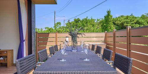 a long table with wine glasses on a patio at Rakuten STAY HOUSE Kujukuri Ichinomiya in Ichigaya