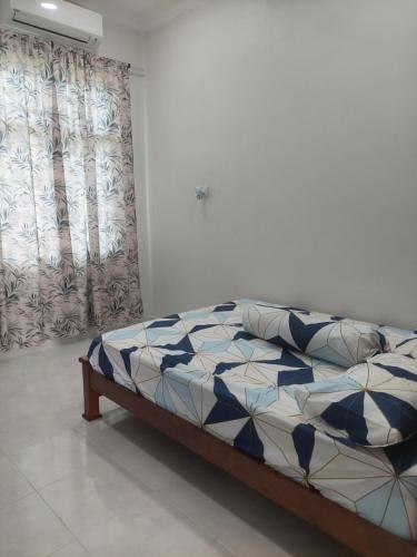 1 dormitorio con 1 cama con edredón azul y blanco en Fathia Homestay Pasir Puteh en Pasir Puteh