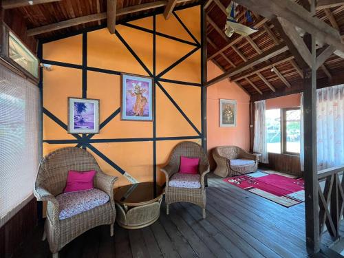 a room with two chairs and a wall with pink pillows at Taverno Villa in Serang