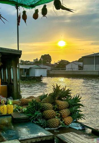 a pile of pineapples sitting on a table near the water at Hometravel Mekong Can Tho in Can Tho