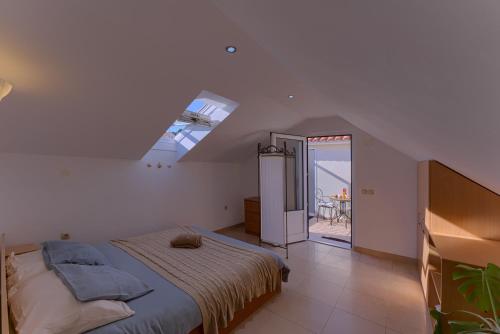 a bedroom with a bed and a skylight at Guest House Dijana in Korčula