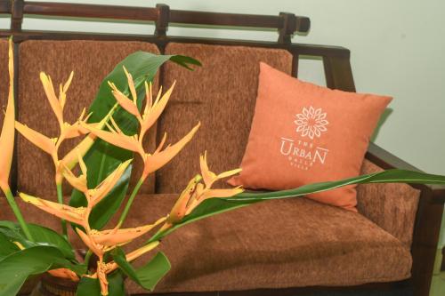 an orange pillow sitting on a chair with a plant at Urban Galle Villa in Galle