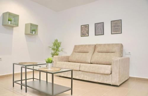 Una sala de estar con un sofá y dos mesas. en Apartamento Goya, en Conil de la Frontera