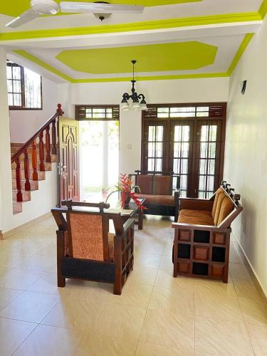 a living room with couches and a table and chairs at Urban Galle Villa in Galle