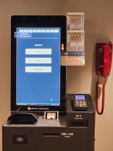 a computer monitor sitting on top of a cash register at Fun Stay Inn Ximen in Taipei