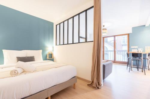 ein Schlafzimmer mit einem großen Bett und einem großen Fenster in der Unterkunft Lille Vauban: apartment with parking in Lille