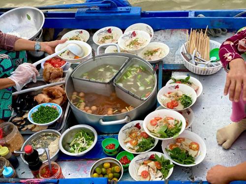 a table with many bowls of food on it at Hometravel Mekong Can Tho in Can Tho