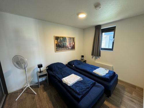 a room with two beds and a fan in it at Enkhuizer Strand Chalet AusZeit Haus Nr 243 in Enkhuizen