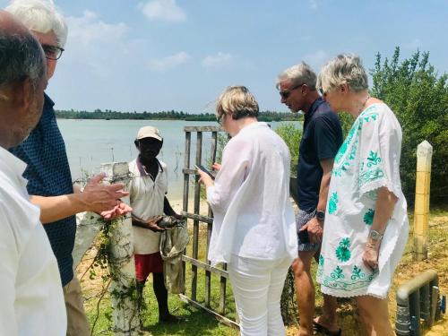 a group of people standing next to a body of water at Koddu Kalpitiya in Kalpitiya