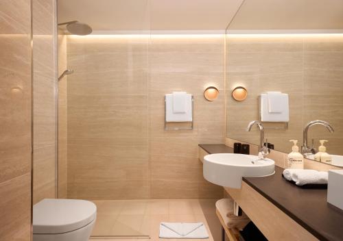 a bathroom with a toilet and a sink at Adina Apartment Hotel Geneva in Geneva