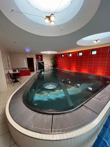 a hot tub in a building with a red wall at Retro Villa Prague 700sqm Indoor-Pool, Sauna, BBQ, table soccer in Prague