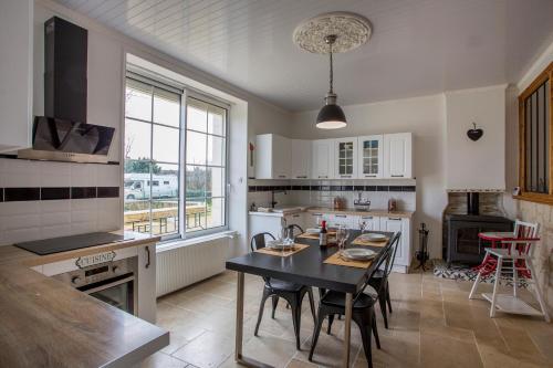 une cuisine avec une table et une salle à manger dans l'établissement L'escapade Vendéenne - Grand jardin 4 chambres, à Vix