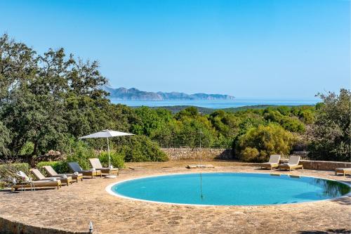 a swimming pool with lounge chairs and an umbrella at Sos Ferres D'en Morey in Manacor