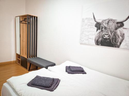 um quarto com uma cama com uma fotografia de um touro na parede em großzügige Altstadtwohnung Lara für 6 Personen em Weißenfels