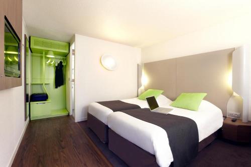 um quarto de hotel com duas camas e um computador portátil em Hôtel Inn Design Resto Novo Nantes Sainte Luce em Sainte-Luce-sur-Loire