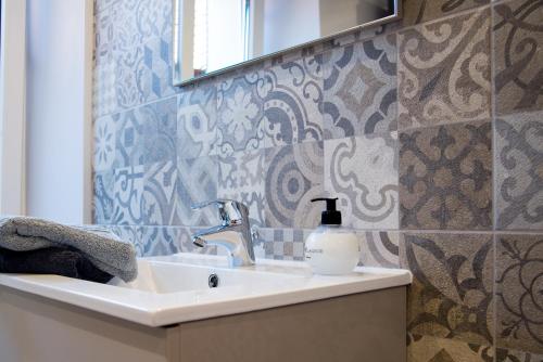 a bathroom with a sink with a soap bottle on it at L’Été en Novembre in Kirrwiller