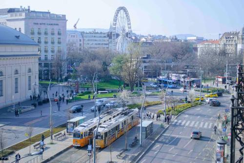 a city with buses and a ferris wheel in the background at Big Wheel Panoramica Apartment II. in Budapest