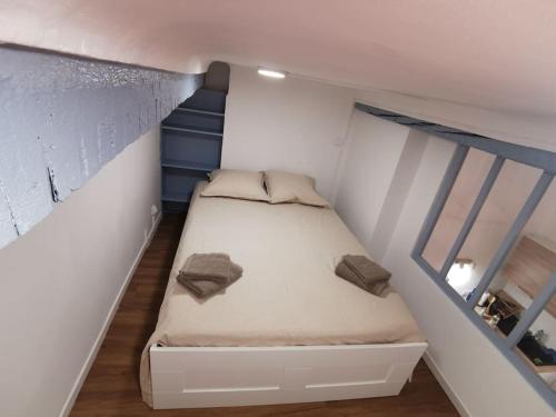 małą sypialnię z łóżkiem w małym pokoju w obiekcie Massalia Apartement, Le Panier w Marsylii