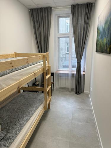 Green Hostel Katowice 24h - Free Parking في كاتوفيسي: غرفة نوم مع سرير بطابقين ونافذة