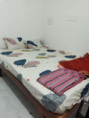 1 cama con edredón y almohadas en Karthik home stay en Hampi