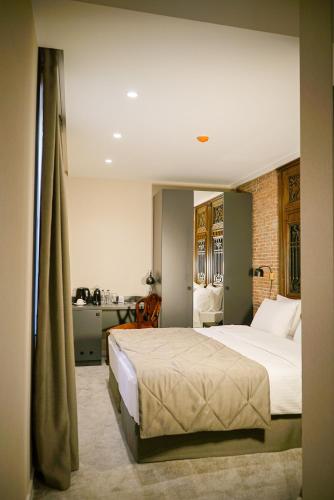 a bedroom with a large bed and a desk at TbiliSee Hotel in Tbilisi City