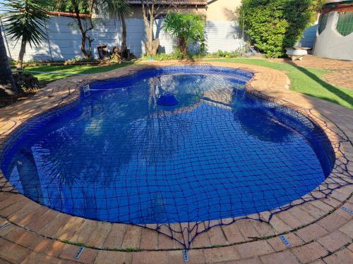 a large blue swimming pool in a yard at Botle Hive in Kempton Park