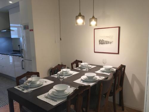 a dining room table with plates and bowls on it at Alegria Cozy com Terraço - Centro do Porto in Porto