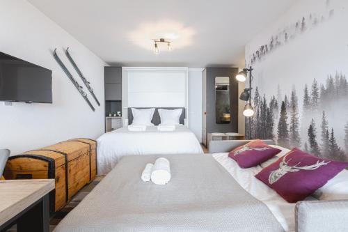 a hotel room with two beds and a couch at Studio rénové avec vue imprenable sur les Alpes in Crans-Montana