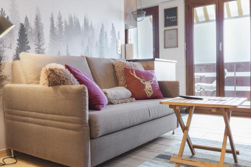 a living room with a couch and a table at Studio rénové avec vue imprenable sur les Alpes in Crans-Montana