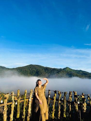 a woman standing on top of a fence in the fog at THIÊN HƯƠNG Homestay Măng Đen in Kon Von Kla