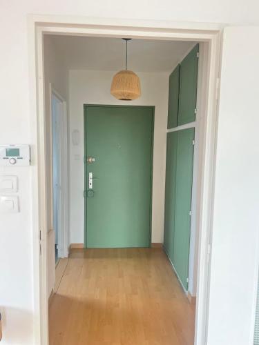 an empty room with green doors and a hallway at Balnéo, Lumineux, Confort in Colmar