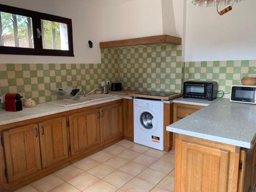 une cuisine avec un lave-linge et un micro-ondes dans l'établissement 2 pièces Arles, à Arles