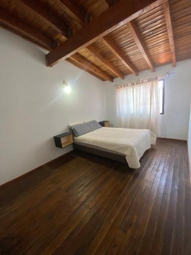 um quarto com uma cama e piso em madeira em Hermoso Dúplex para 4 personas em Las Heras
