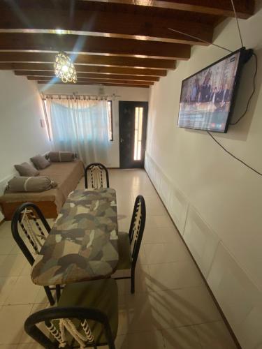 uma sala de estar com uma mesa, um sofá e uma televisão em Hermoso Dúplex para 4 personas em Las Heras