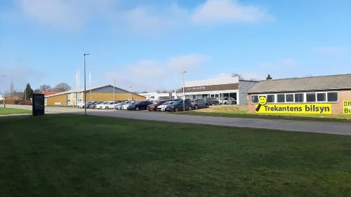 un estacionamiento con autos estacionados frente a un edificio en Kolding Sportel, en Kolding