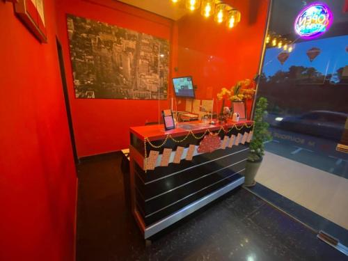 a restaurant with a counter in a red room at M BOUTIQUE INN (PERMYJAYA) in Miri