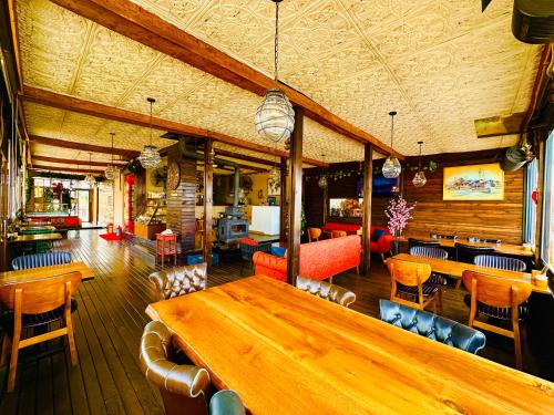 un restaurante con una gran mesa de madera y sillas en Villa Siesta Hotel Istanbul Airport, en Karaburun