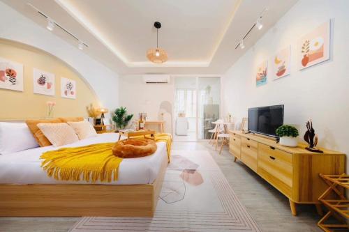 - une chambre avec un grand lit et une couverture jaune dans l'établissement Srithana Condominium Cozy Room, à Chiang Mai