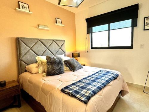 1 dormitorio con 1 cama grande y ventana en Depto lujo Querétaro climatizado, en Querétaro