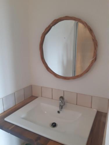 ein Waschbecken mit einem Spiegel an der Wand in der Unterkunft Grande maison familiale avec piscine proche Avignon in Bagnols-sur-Cèze